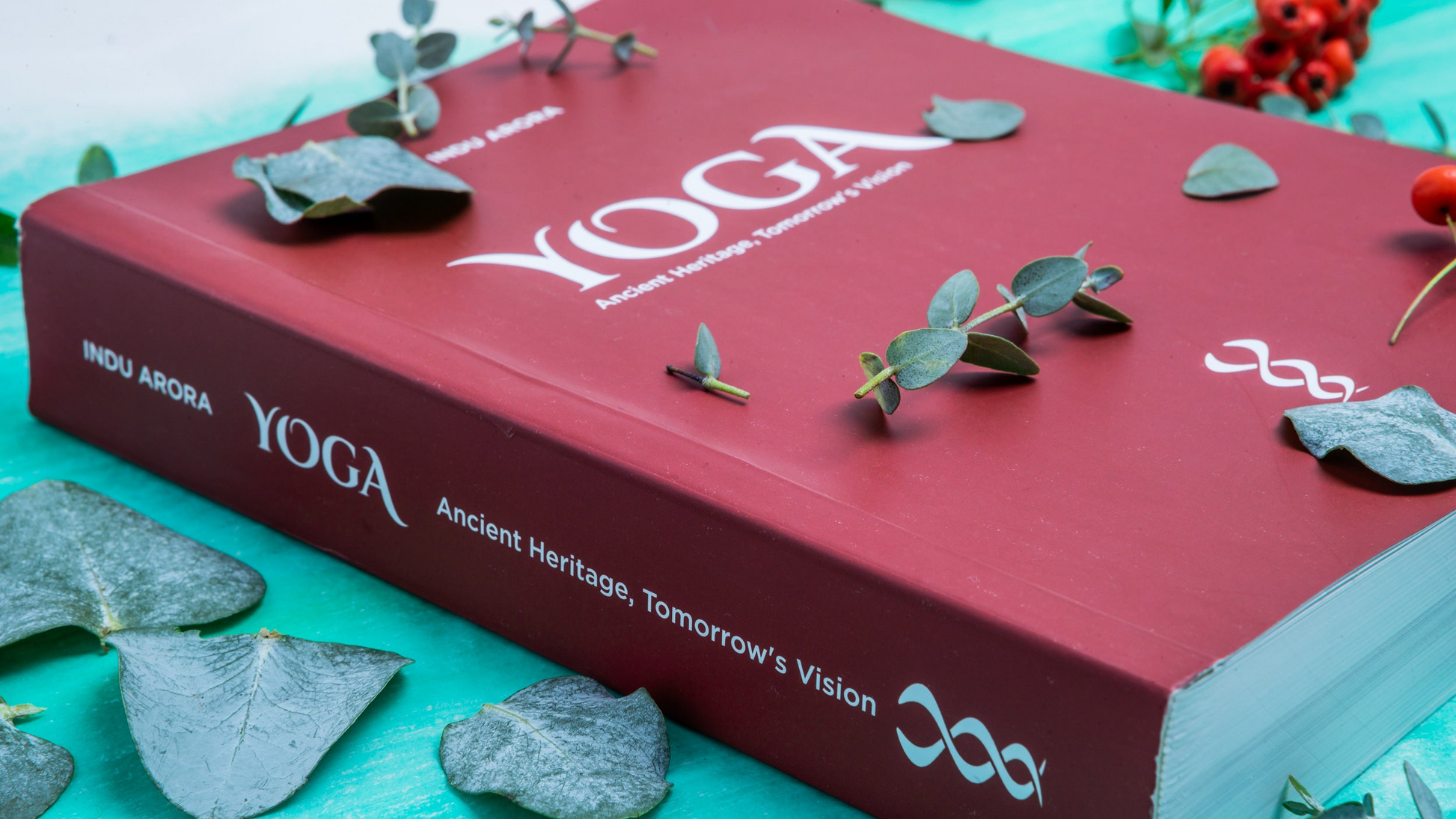 Red book titled 'Yoga' on a teal background with decorative elements